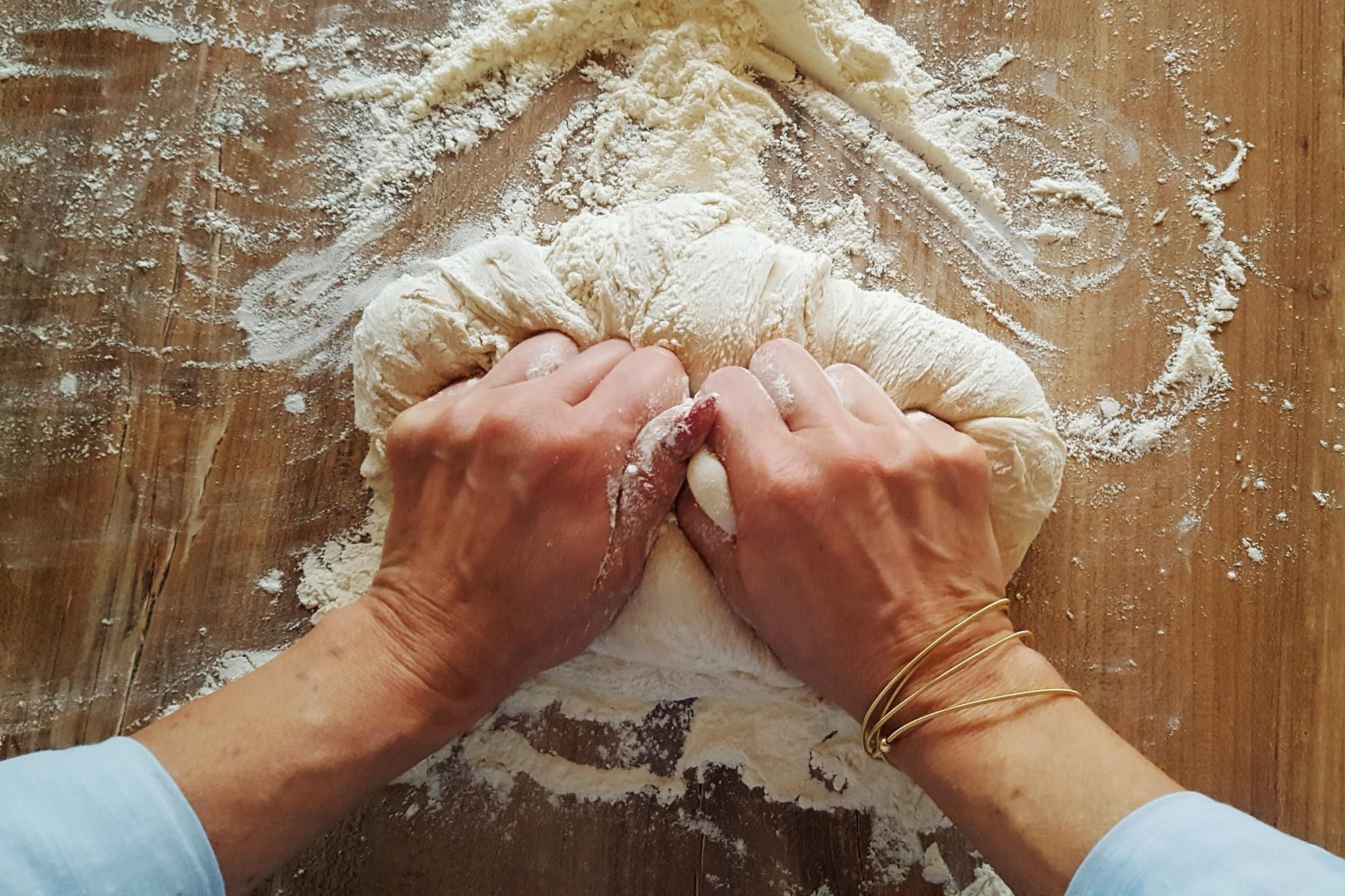 Mano che impasta sulla spianatoia